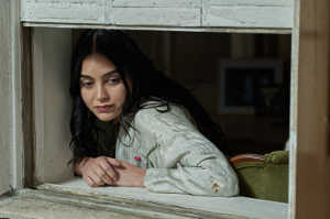 Julie Rivers (Melissa Barrera) en la ventana de su casa nueva